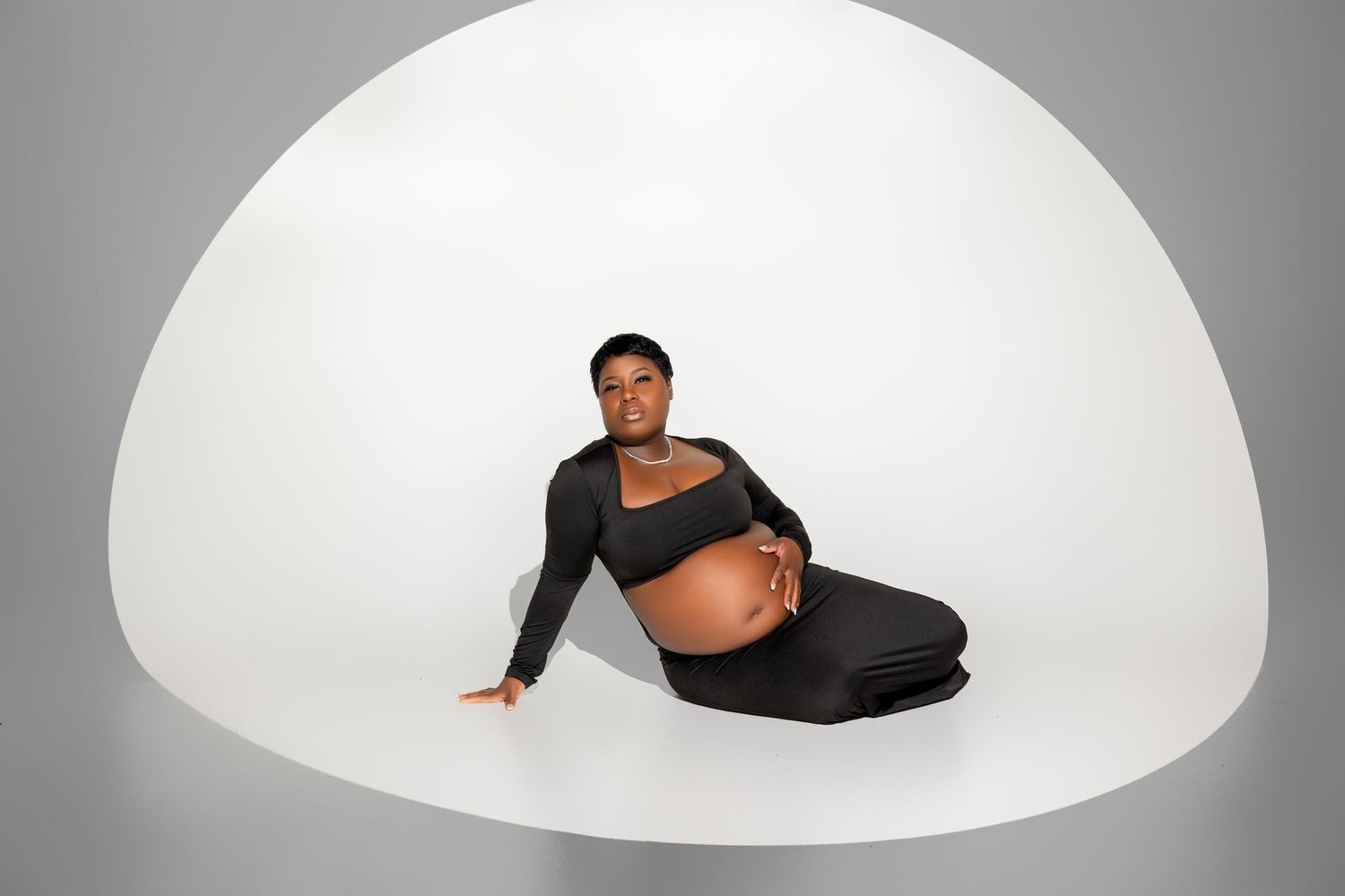 Curved white architectural dome structure shown in multiple views with a figure demonstrating its scale and interior space.