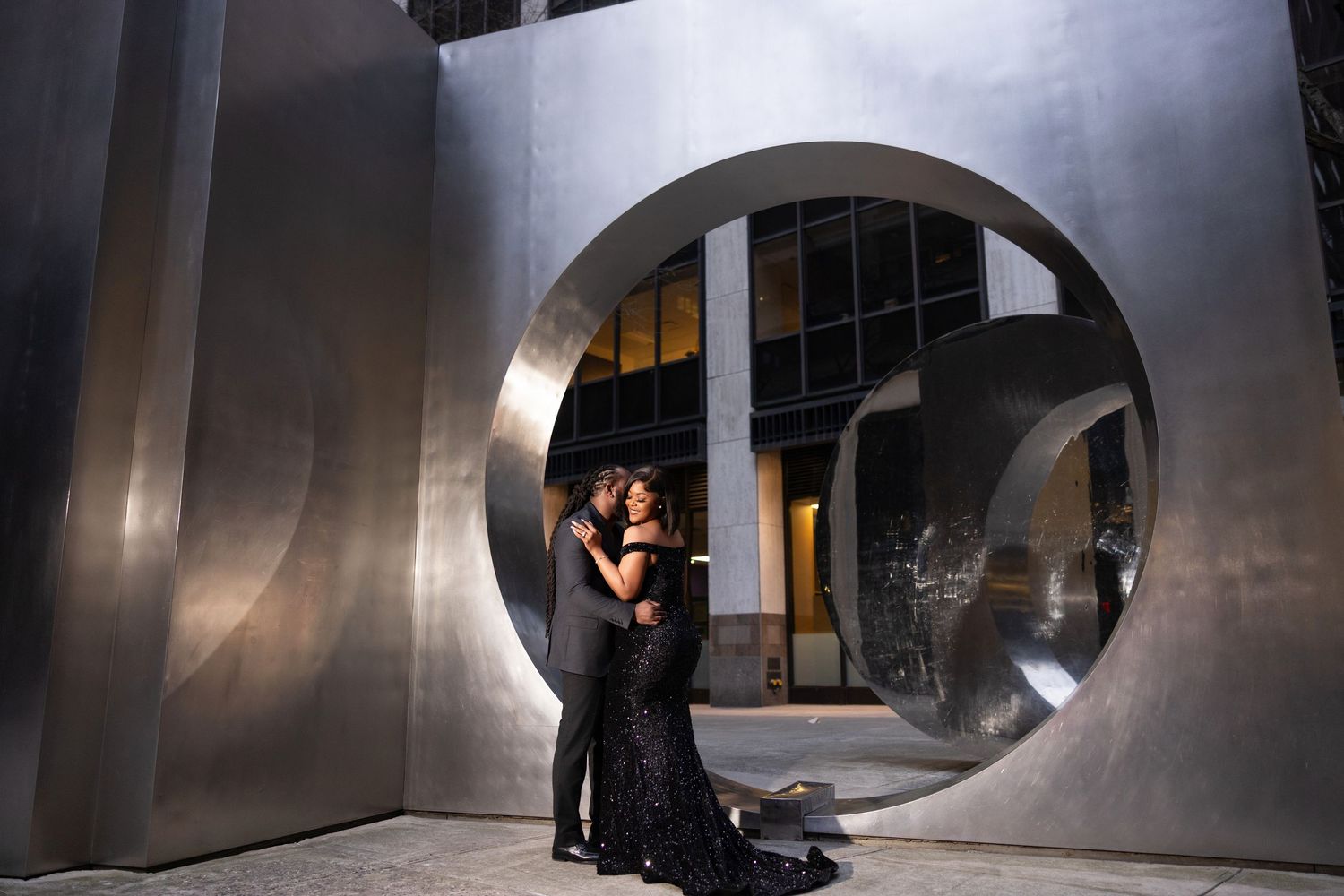 Interior architectural view of curved concrete walls with dramatic lighting and arched windows in a modern space.