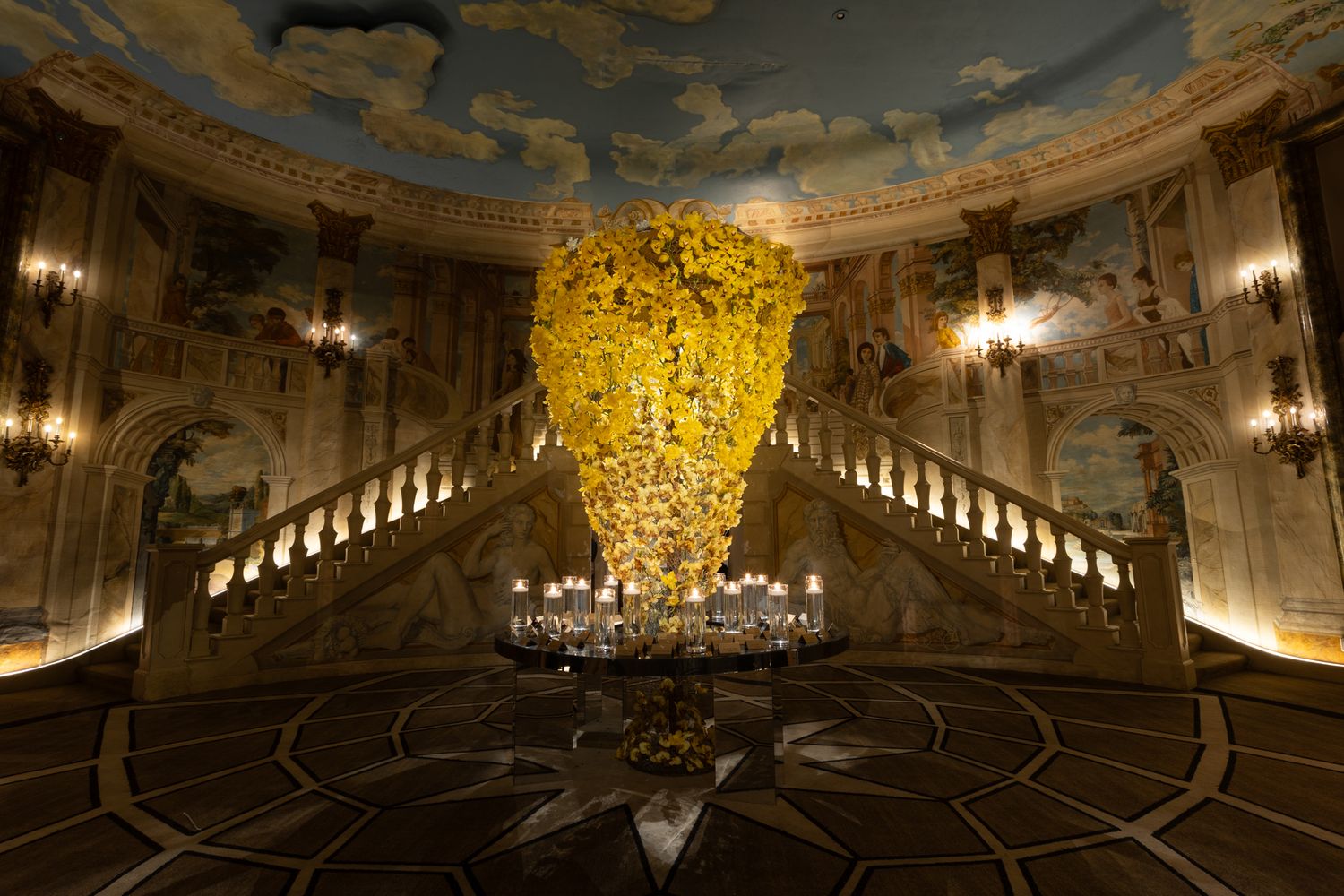 Ornate baroque palace interior with gilded decorations, frescoed ceiling, and crystal chandeliers in a grand ballroom.