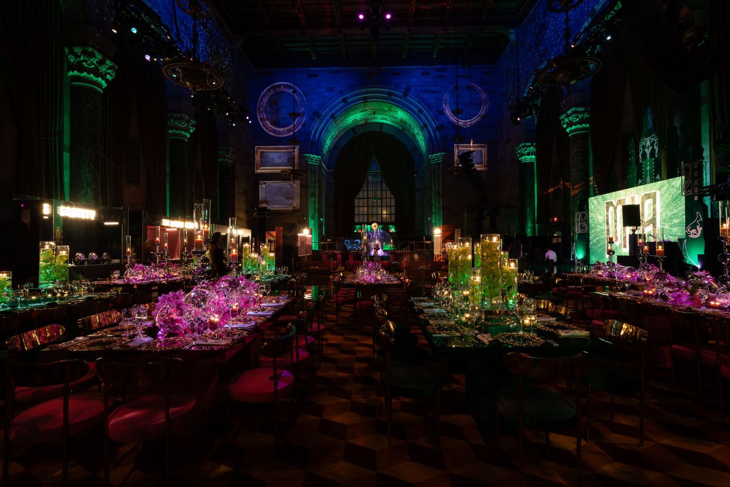 Dark ballroom illuminated with dramatic blue and purple lighting effects creating a mysterious ambiance.