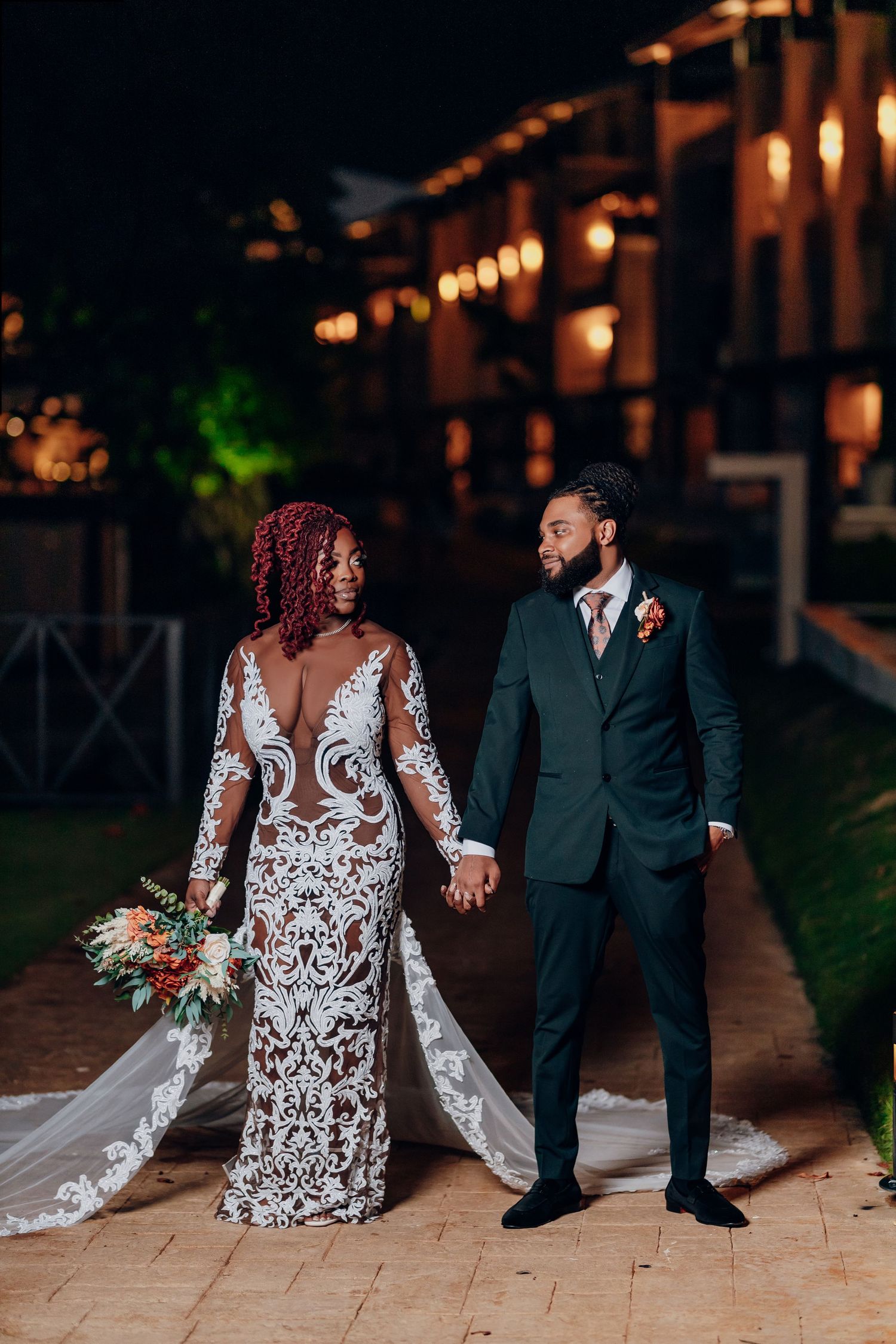 A romantic evening wedding scene shows couples in formal attire walking along a lit pathway.