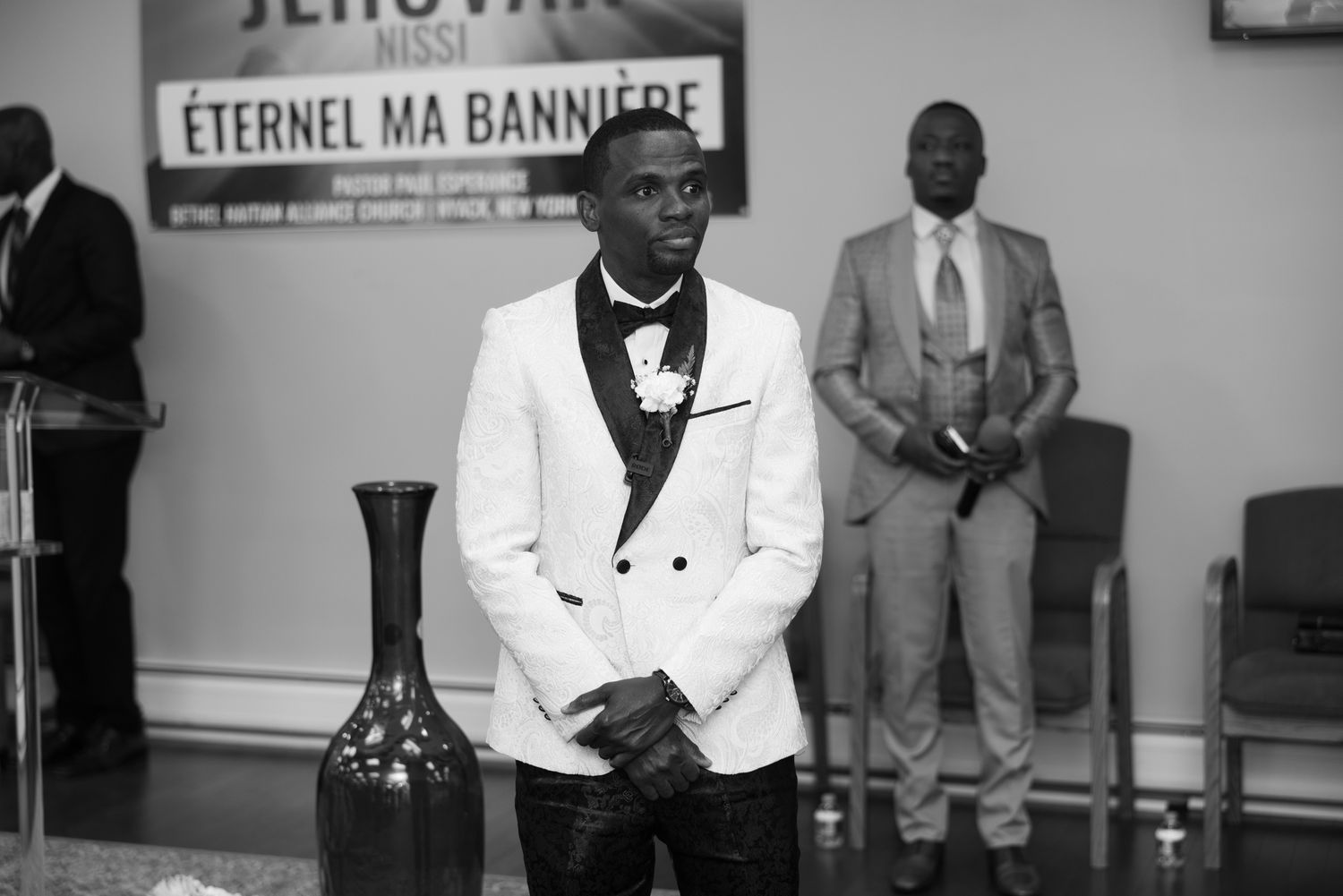 Wedding ceremony decor and seating area with a sign display in black and white tones.