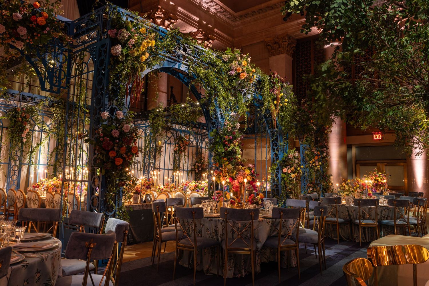 Elegant ballroom decorated with twinkle lights and greenery arches creating a romantic indoor garden atmosphere.
