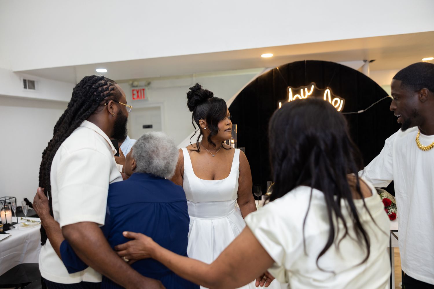 Wedding celebration with guests gathering under black arch decor.