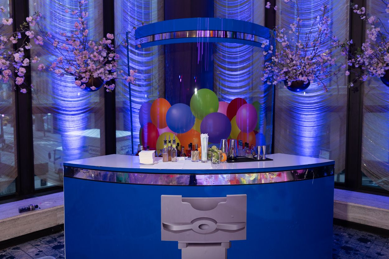 Elegant ballroom reception setup with blue uplighting, crystal chandeliers, and white table settings.