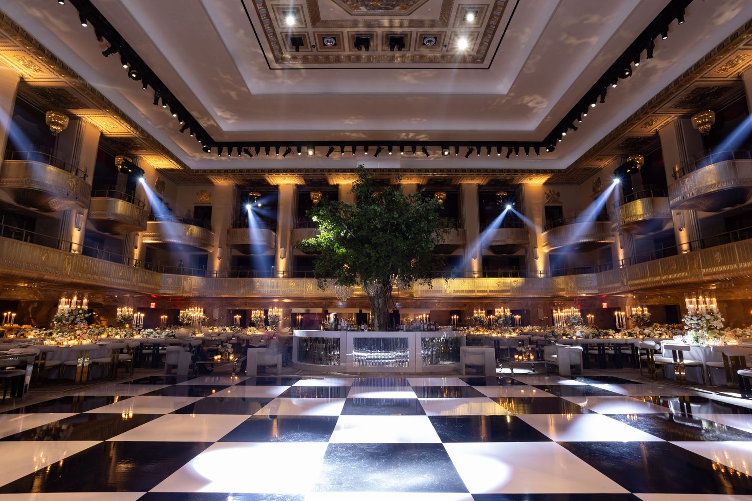 Panoramic view of an elegant ballroom with ornate ceiling details and dramatic lighting creating a luxurious atmosphere.