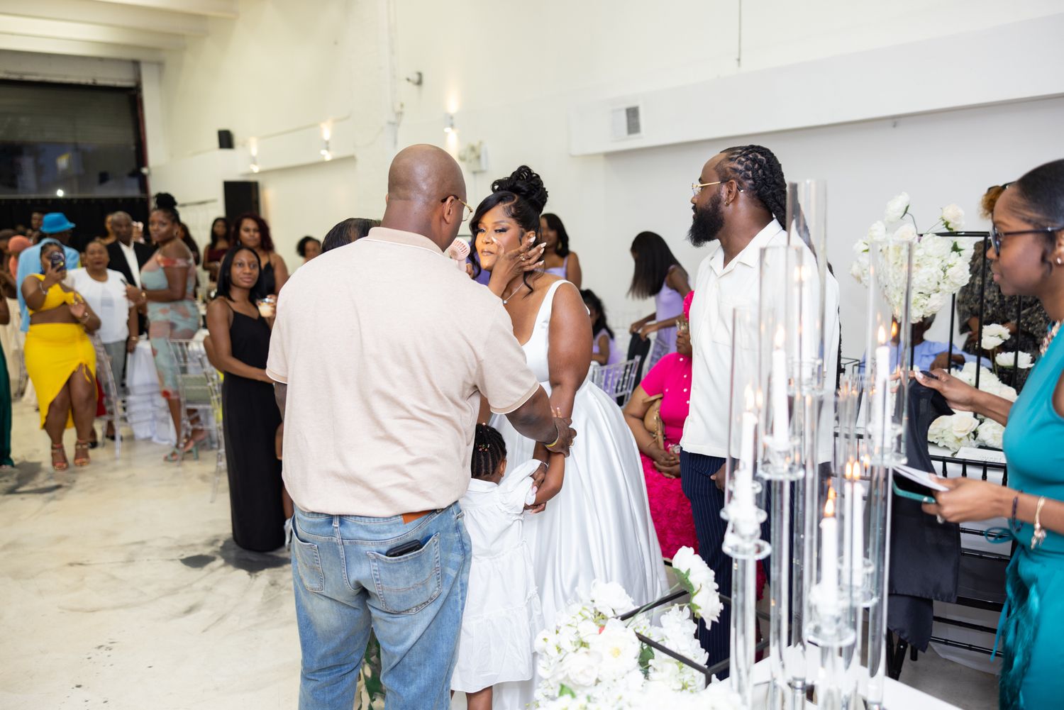 Wedding reception scene with guests gathered around decorative display.