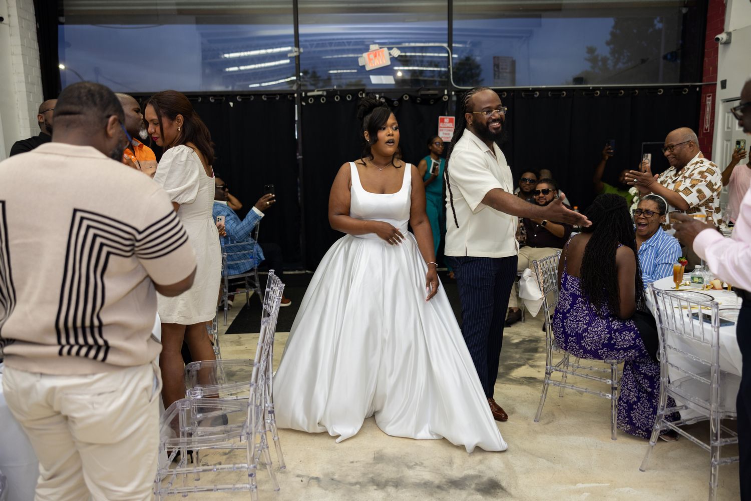 Wedding celebration with guests dancing and mingling in a reception hall.