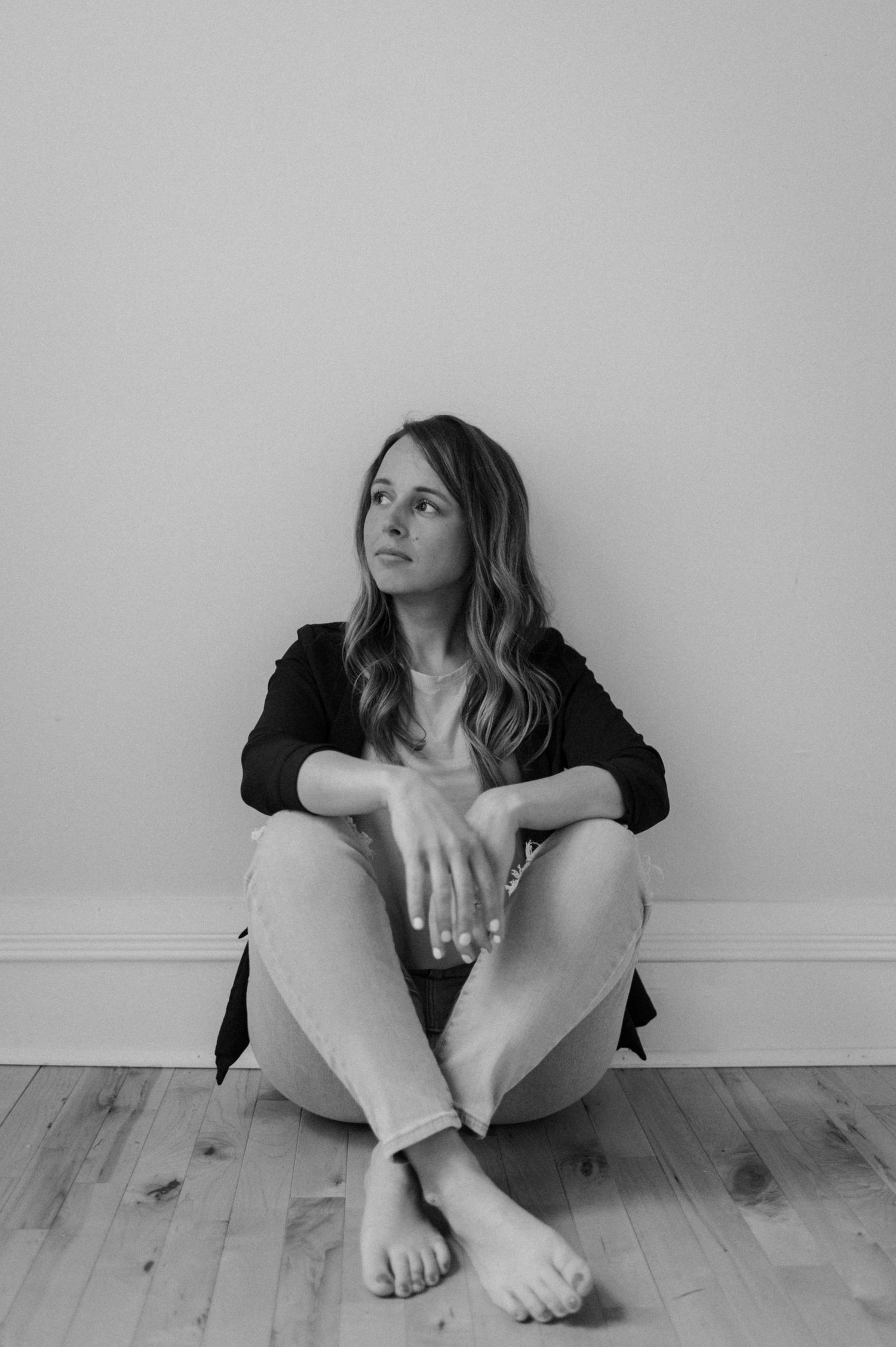 Black and white artistic photo series showing a person sitting against a wall in different contemplative poses.
