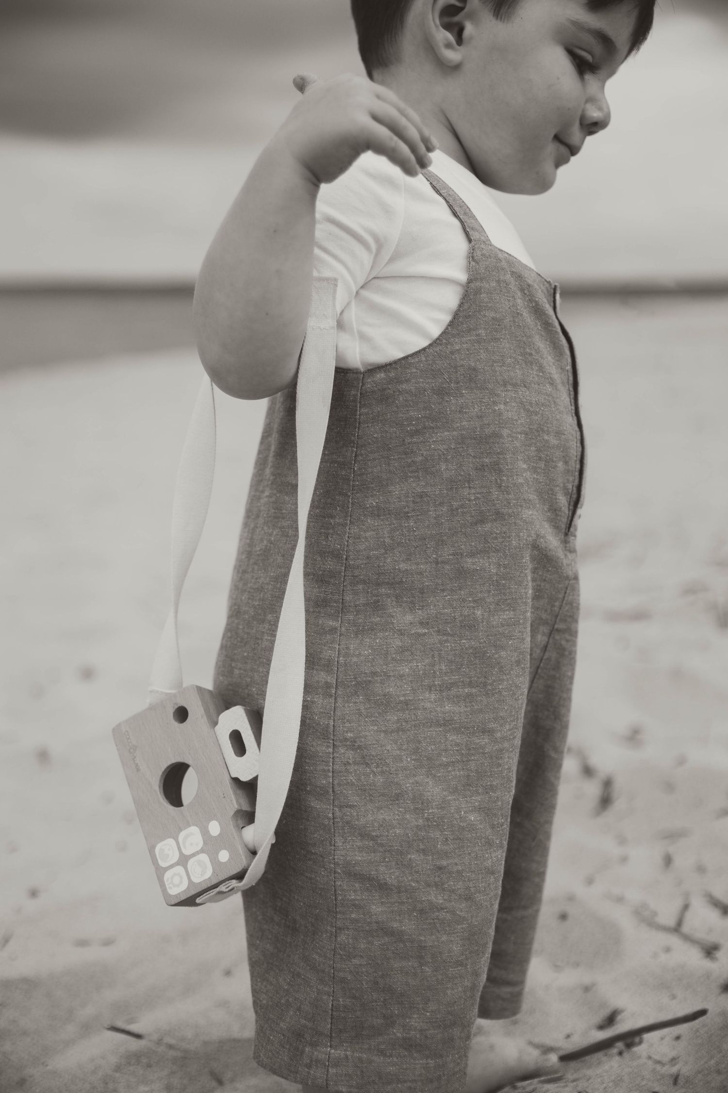 Close-up view of someone wearing a gray sleeveless top on the beach.