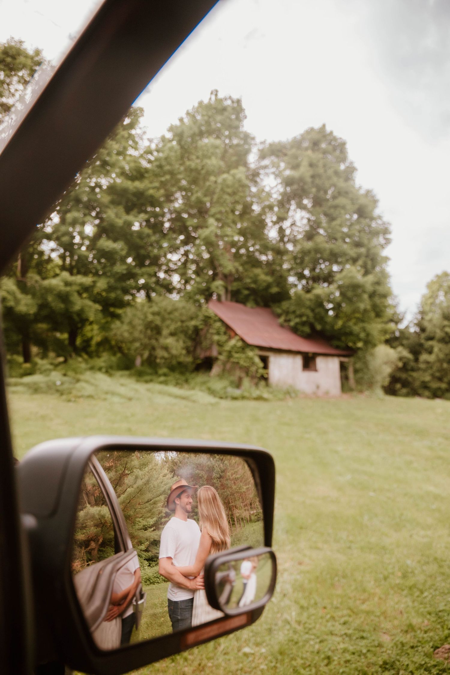 A series of car mirror reflection shots showing a couple in a grassy field with a small building.