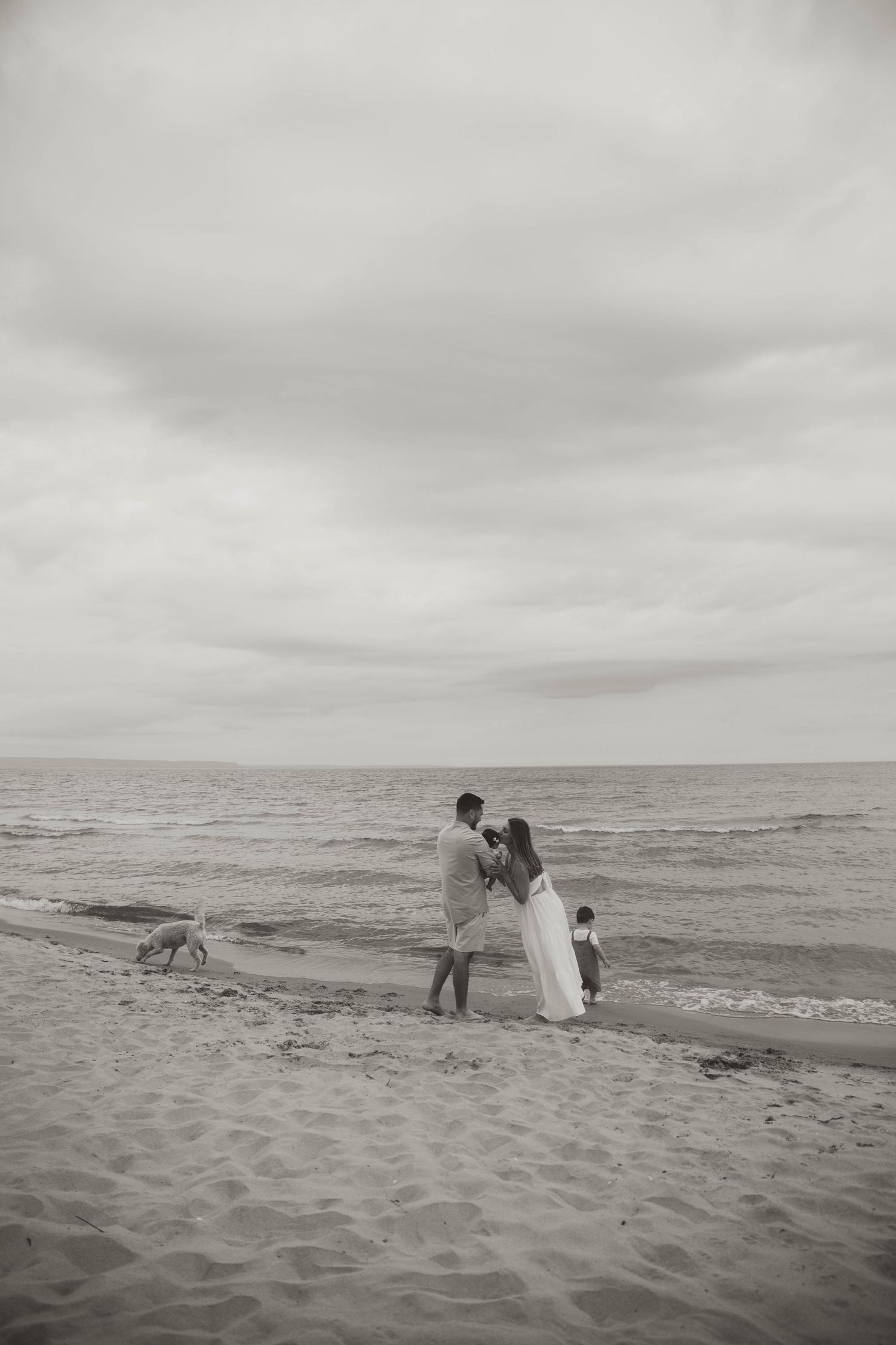Black and white photo of people enjoying a peaceful moment on a beach.