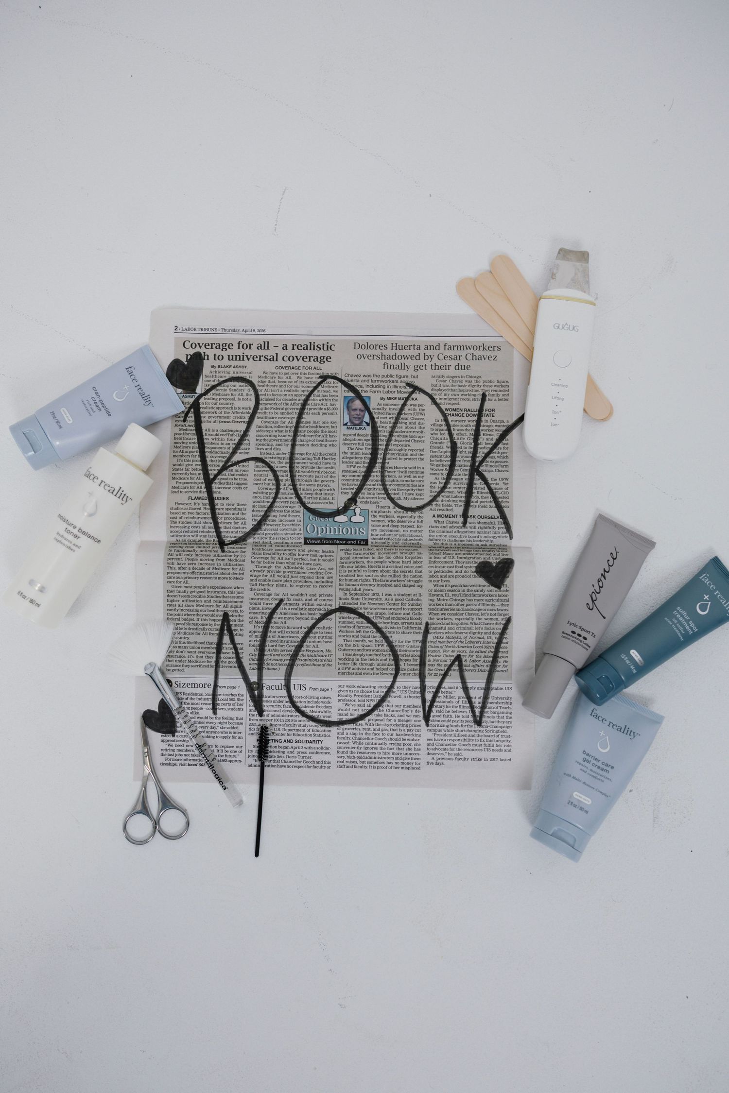 Flatlay of skincare products and beauty tools surrounding a newspaper with BOOK NOW written on it.