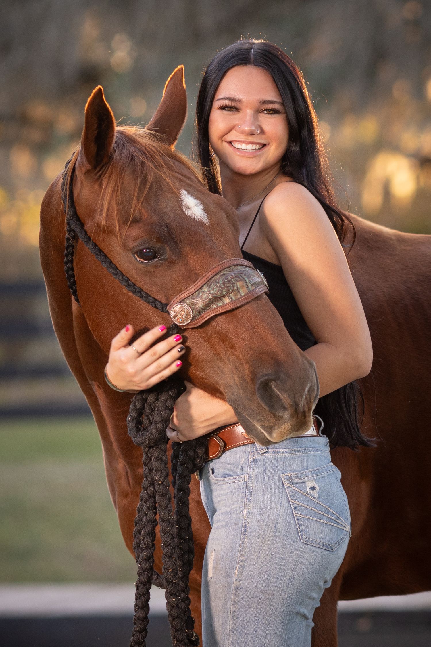 Series showing affectionate moments with a senior graduation portrait session with equestrian and horse  in golden afternoon light.