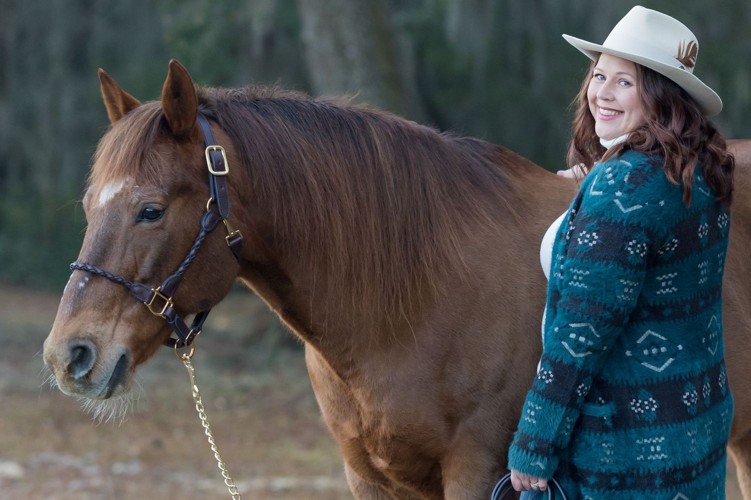 AQHA gelding  standing calmly in nature while being photographed with owner in Florida during horse rider portrait session with Keli Wakeley