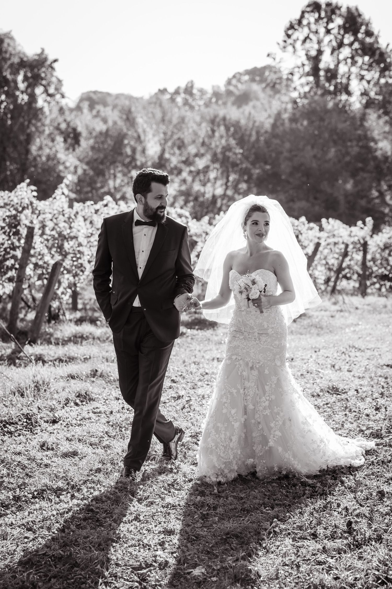 A black and white photo series shows a couple playfully running through an outdoor field on their wedding day in NYC.