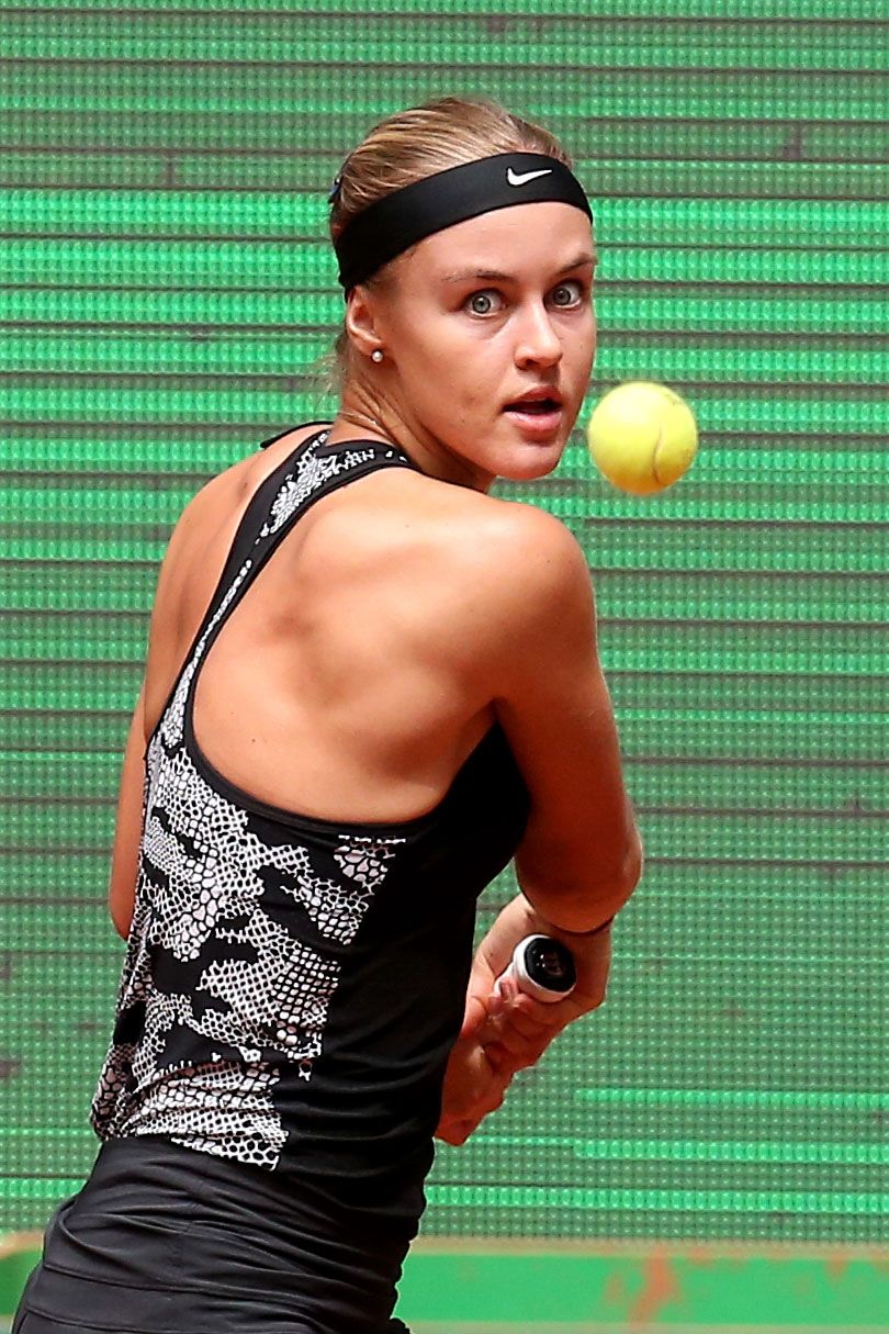 Female tennis player serving during competitive match – NYC sports photographer