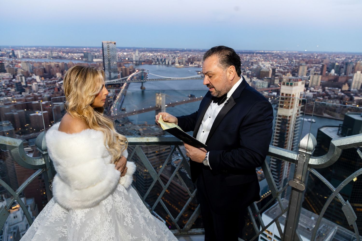 Epic wedding photography on an NYC observation deck, capturing a romantic moment with the entire city skyline as a backdrop.
