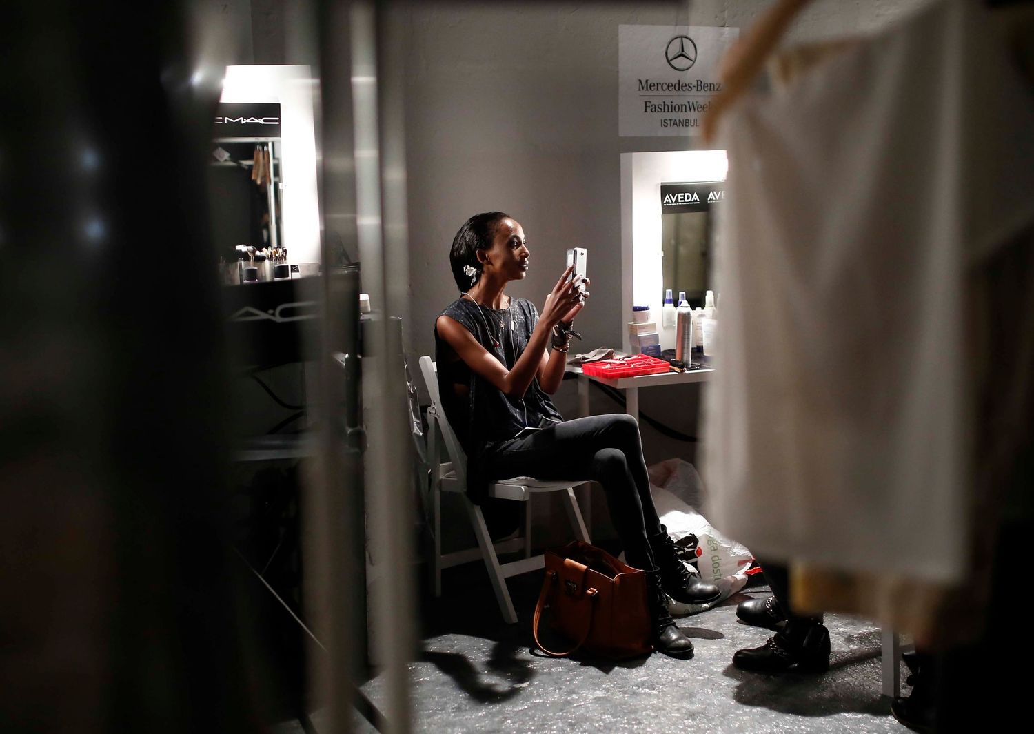 Candid backstage scene during New York Fashion Week — makeup, styling, and final runway prep captured documentary-style.