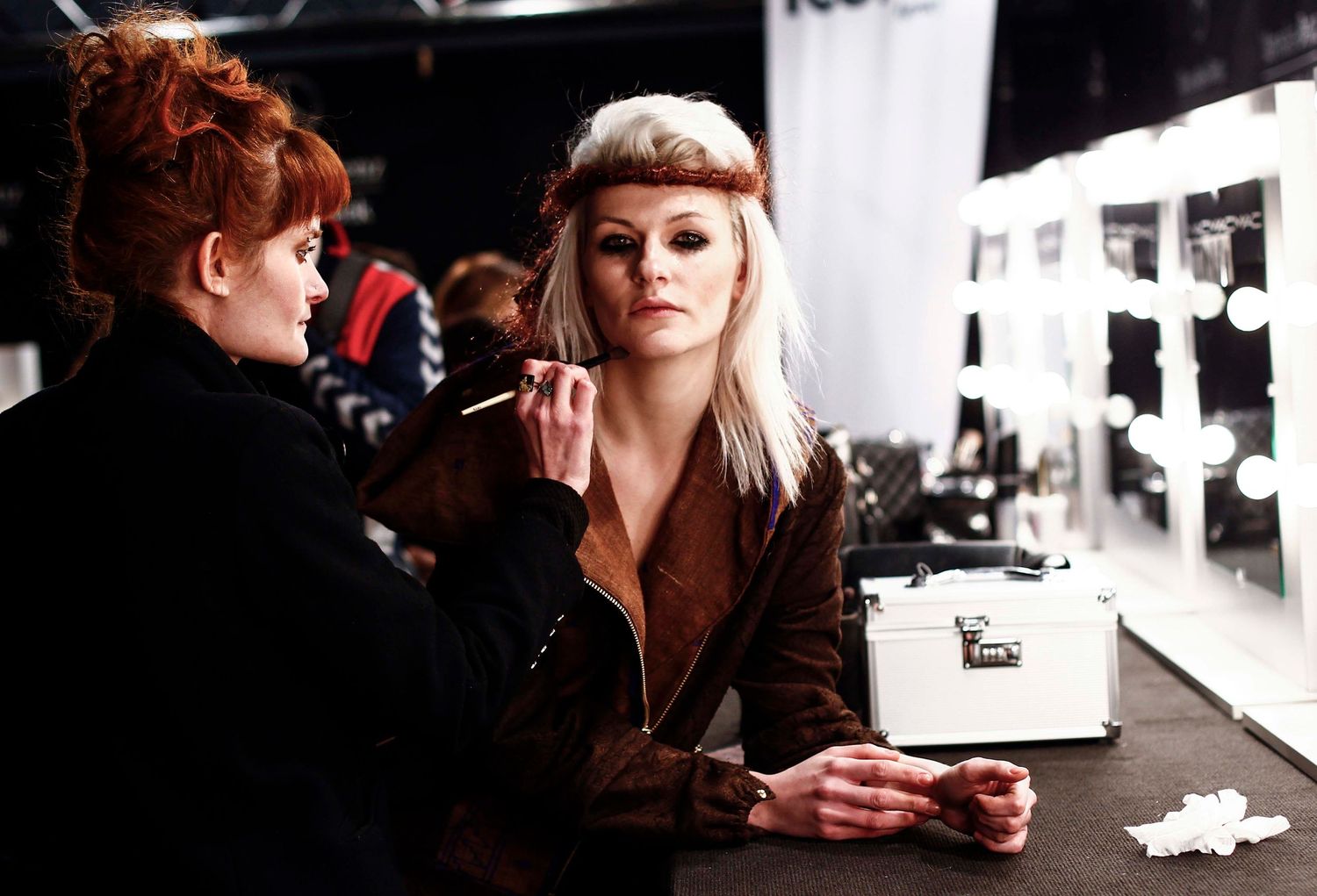 Candid backstage scene during New York Fashion Week — makeup, styling, and final runway prep captured documentary-style.