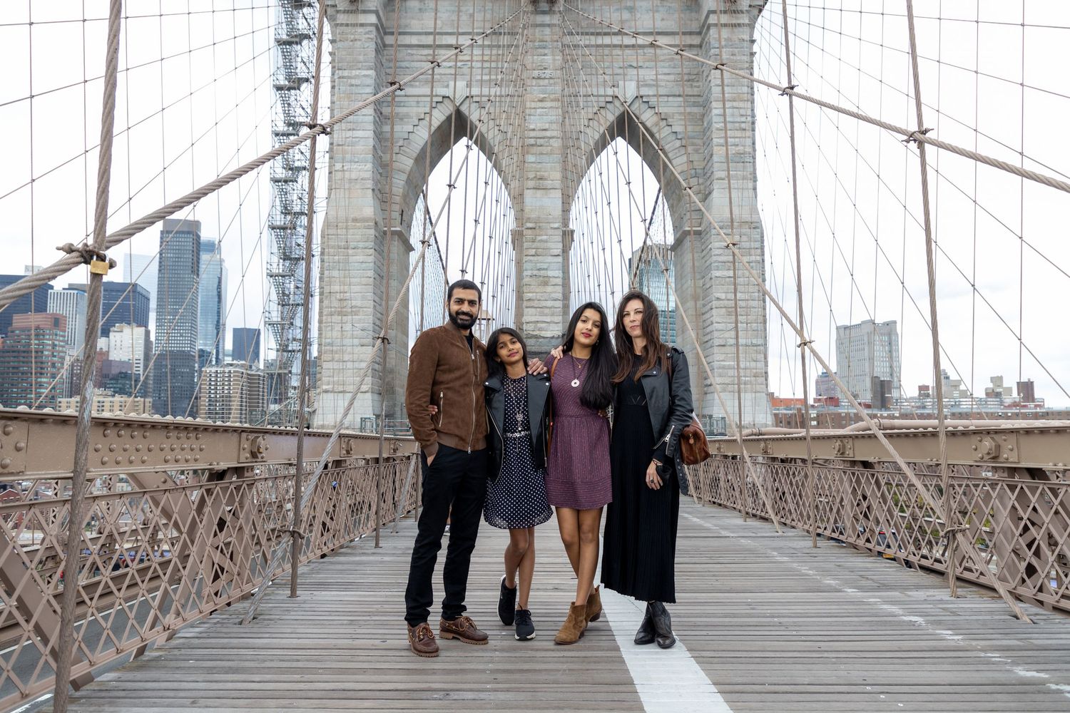 Family photo session on the Brooklyn Bridge in New York City — natural, joyful portraits with an iconic skyline backdrop.