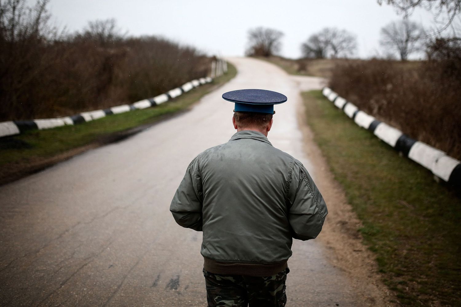 Ukrainian soldier walking away from an occupied military base during the Russian invasion — powerful photojournalism from the frontline.
