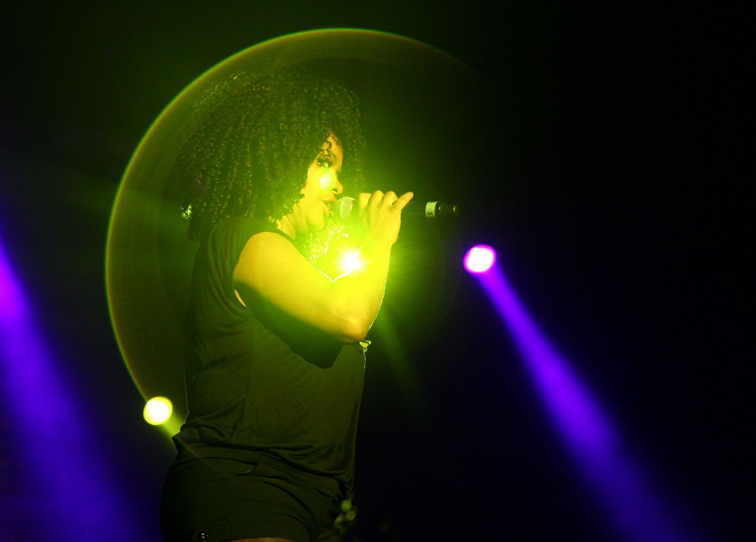 Female singer performing live on stage during a concert in NYC — powerful concert photography capturing music and emotion.