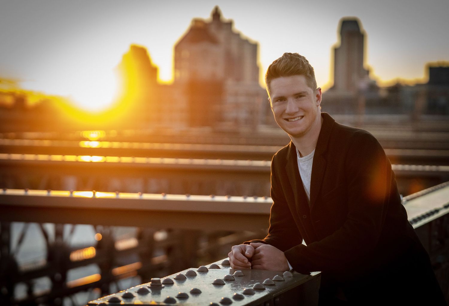 Candid senior portrait on the Brooklyn Bridge — celebrating graduation with iconic NYC views.
