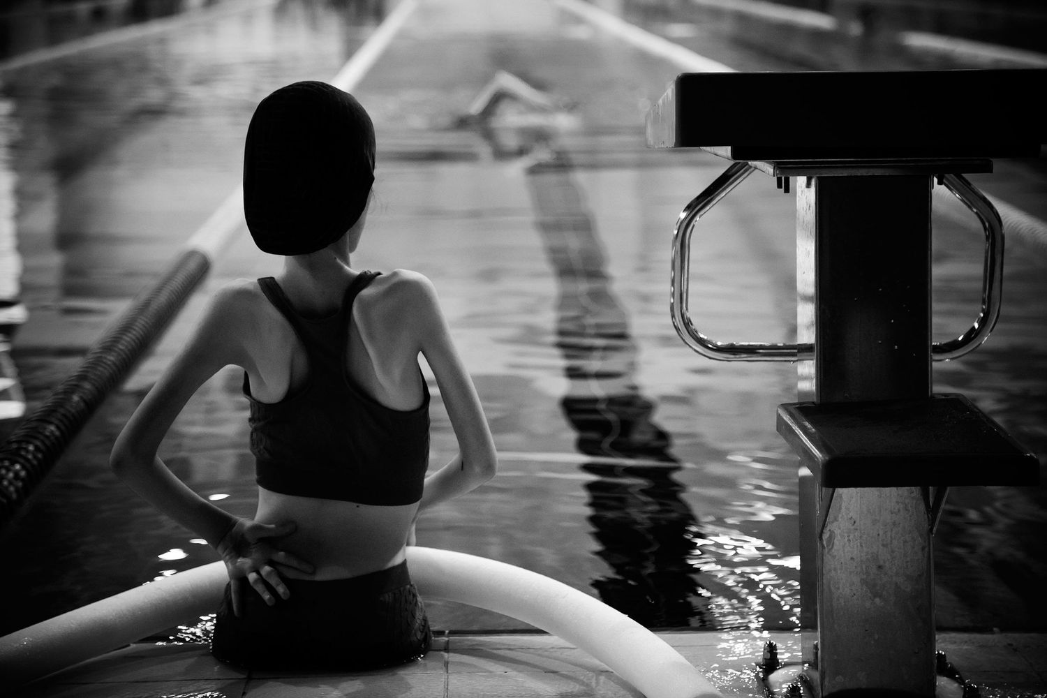 Young swimmer with a disability preparing to enter the pool — powerful image of determination and inclusion in youth sports.