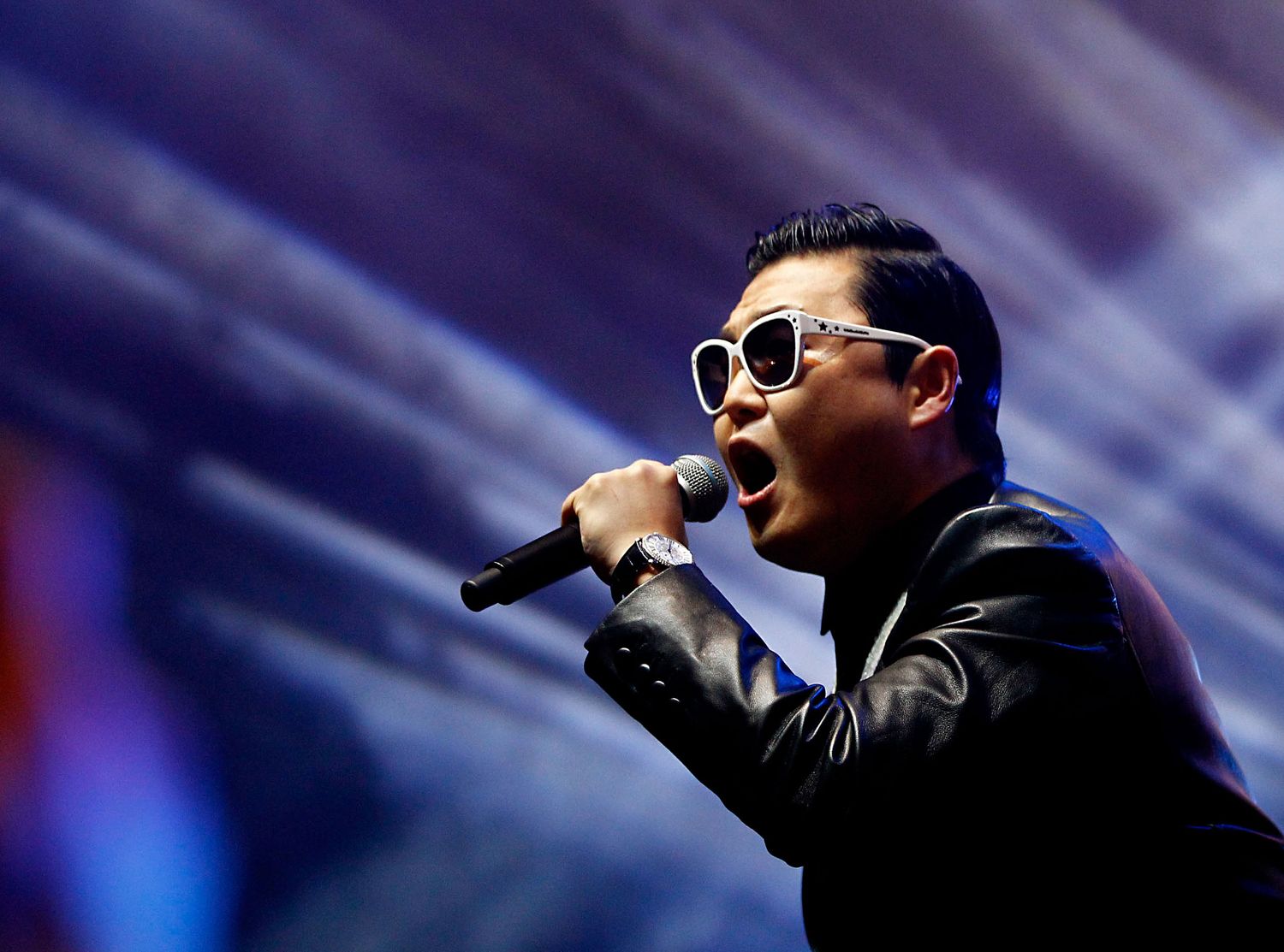 PSY performing live on stage in New York City — high-energy K-pop concert photography capturing movement and crowd excitement.