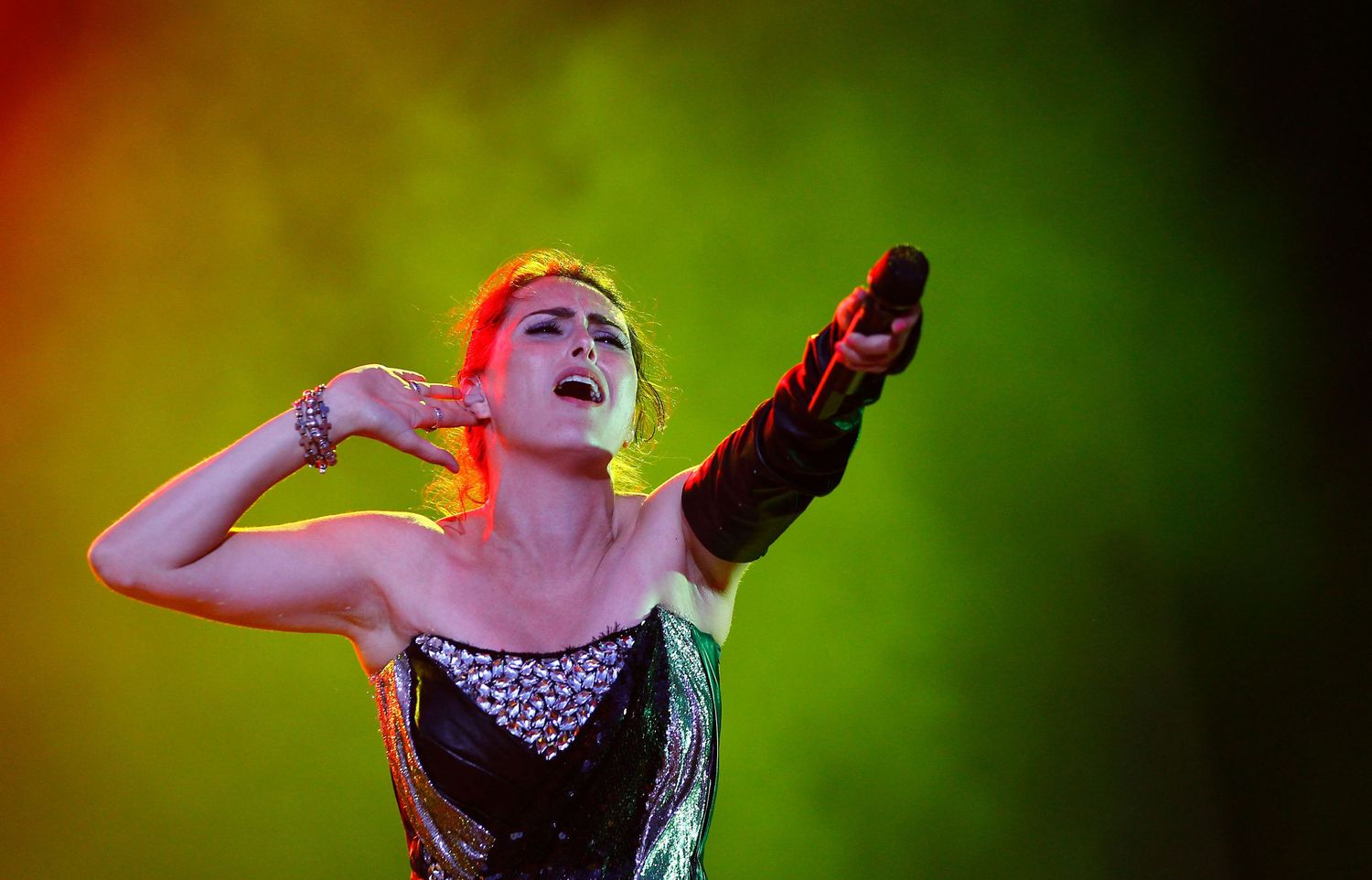 Female singer performing live on stage during a concert in NYC — powerful concert photography capturing music and emotion.