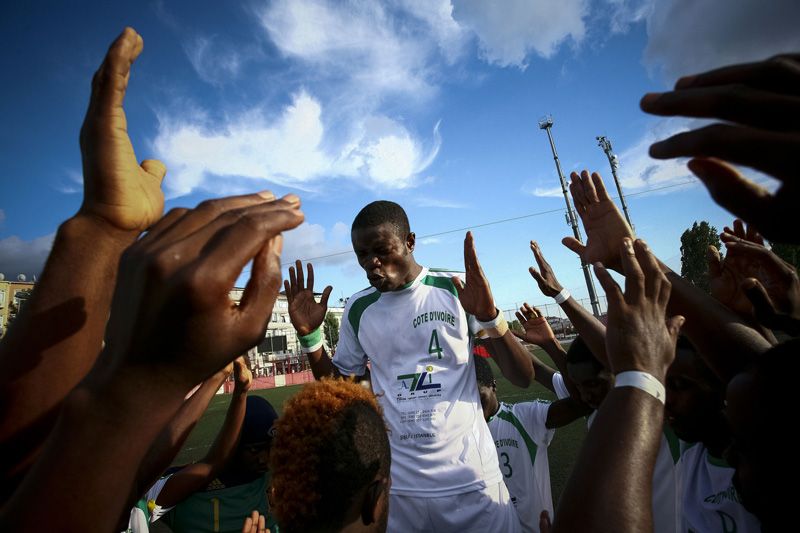 Soccer players joining hands in prayer before the match — emotional pre-game ritual captured with photojournalistic style.