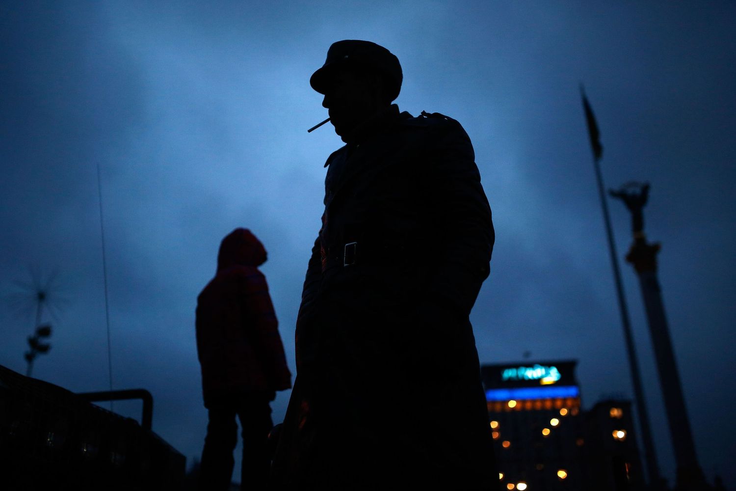 Silhouette of a man standing on a tank during the Maidan protests in Kyiv, captured at blue hour — powerful symbol of resistance.