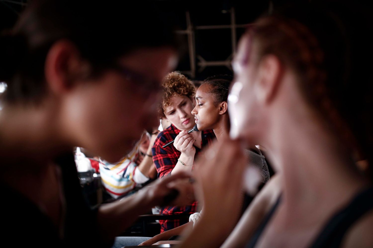 Candid backstage scene during New York Fashion Week — makeup, styling, and final runway prep captured documentary-style.