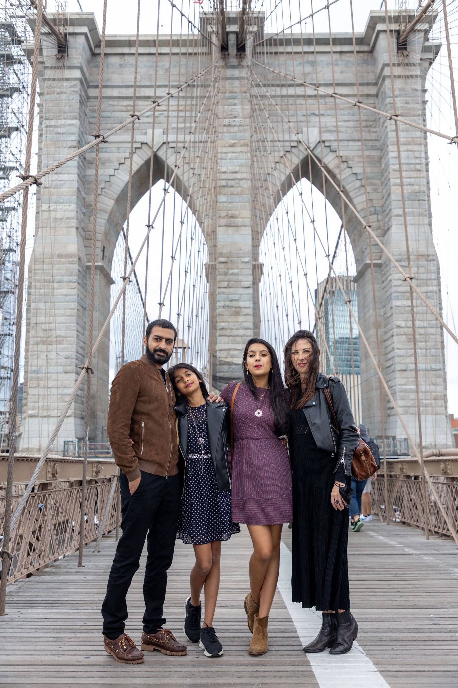 Family photo session on the Brooklyn Bridge in New York City — natural, joyful portraits with an iconic skyline backdrop.