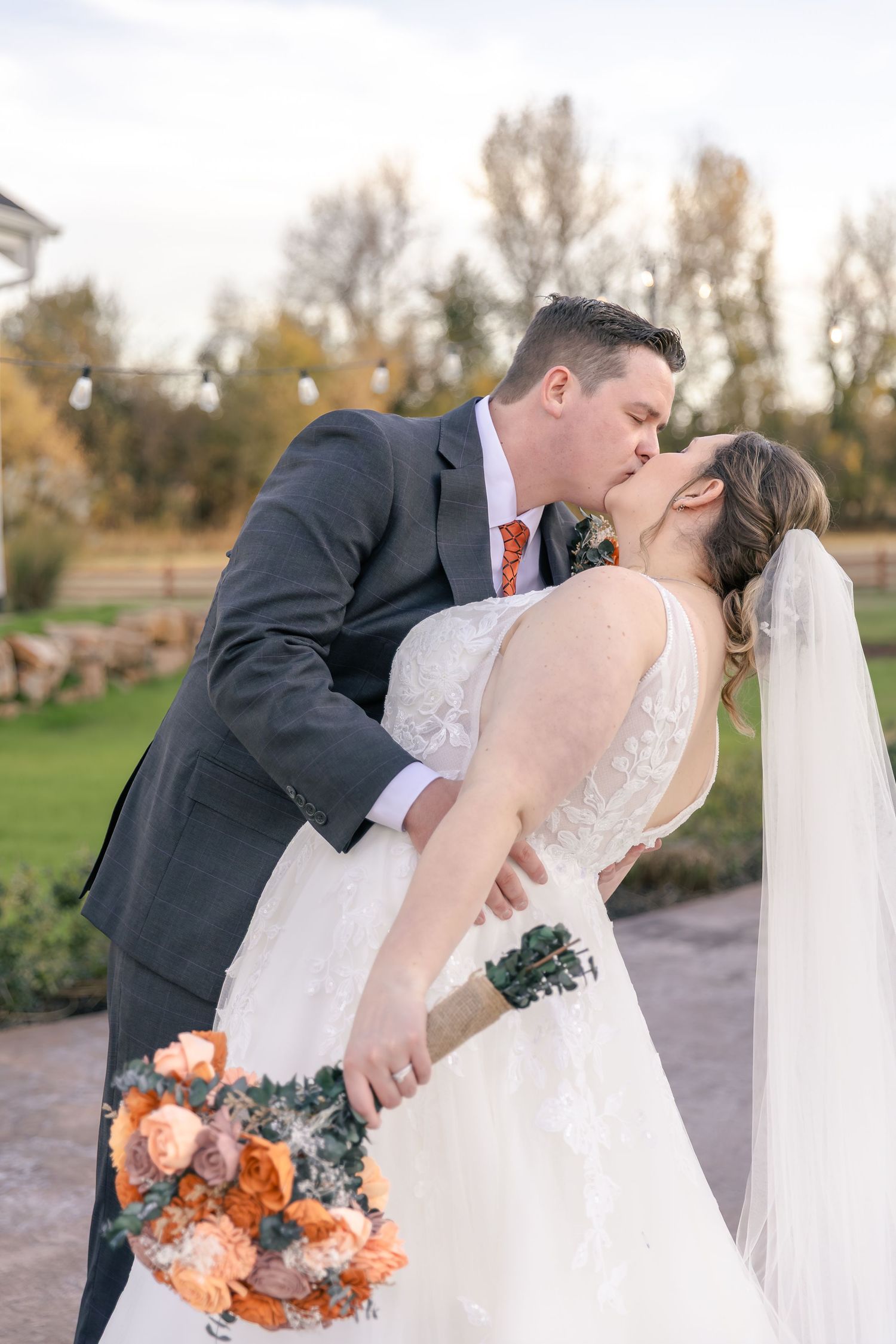 Romantic wedding couple sharing intimate kisses during their autumn outdoor photoshoot.