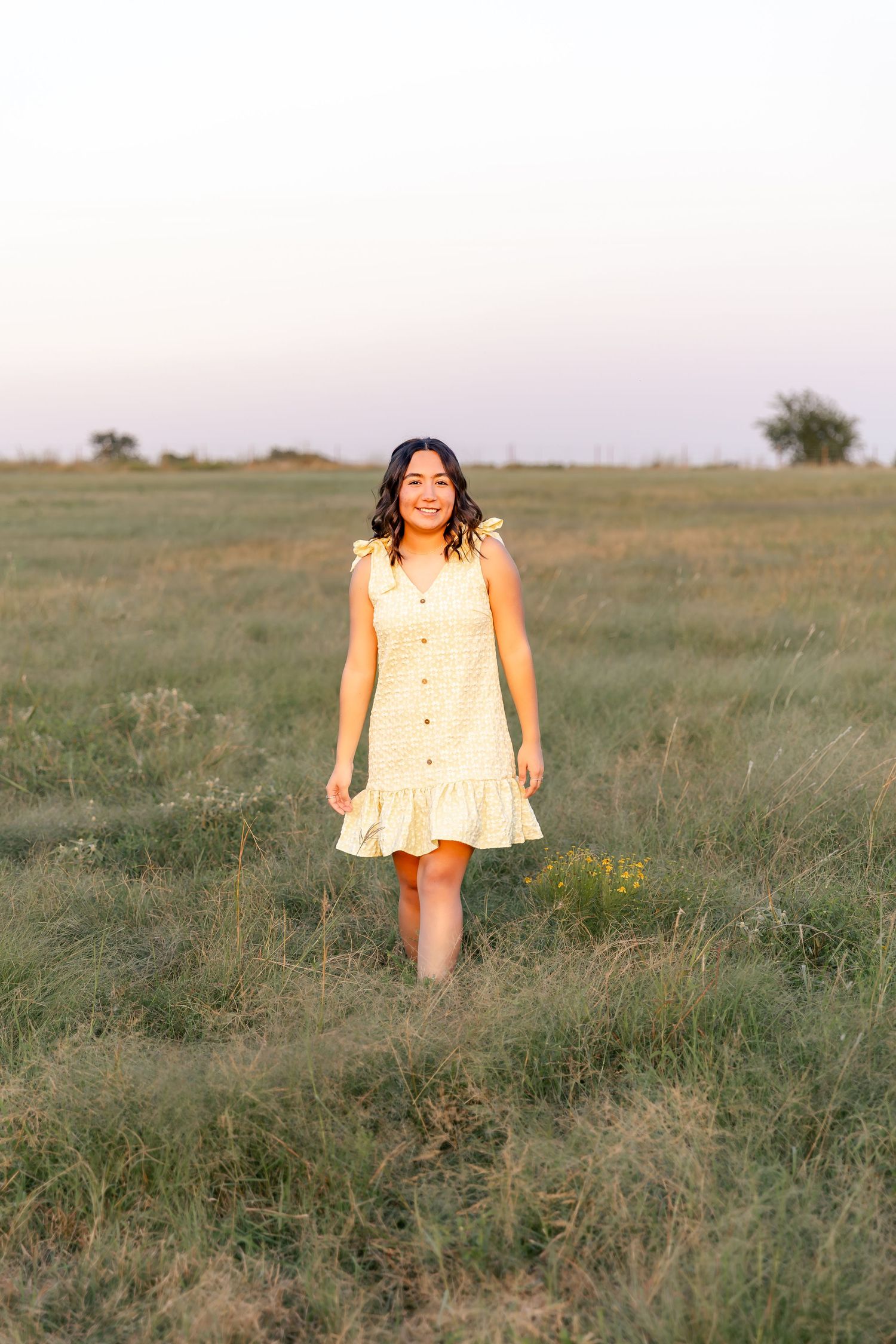 A playful series of senior poses in a cream-colored dress against a natural outdoor setting.