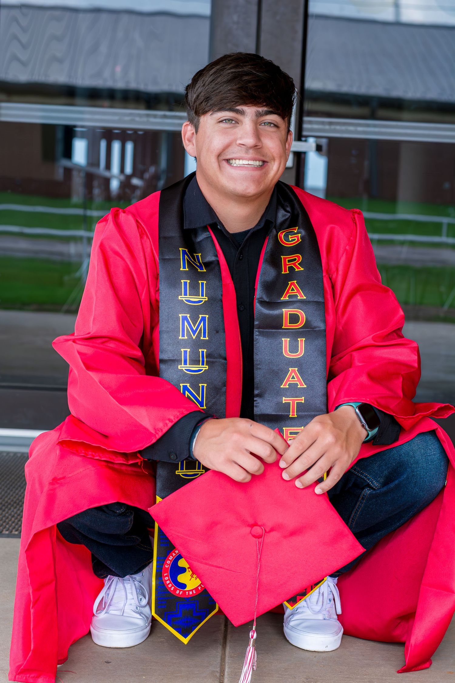 A Senior Student wearing graduation stoles with embroidered designs.