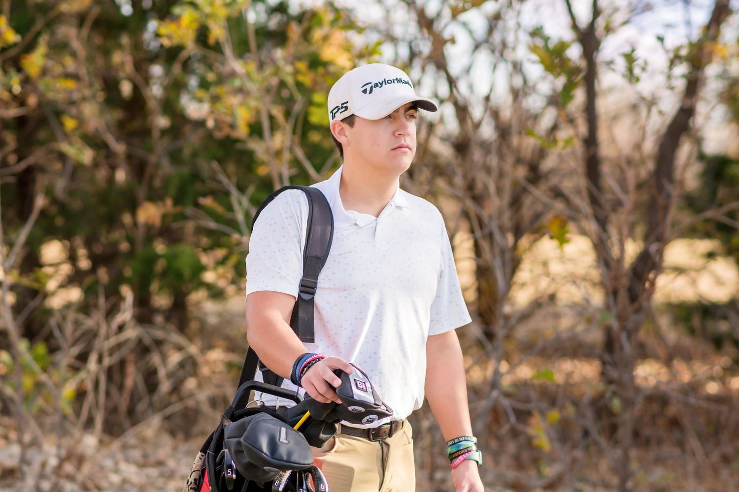 A Senior Golfer in white attire is analyzing the green during a game.