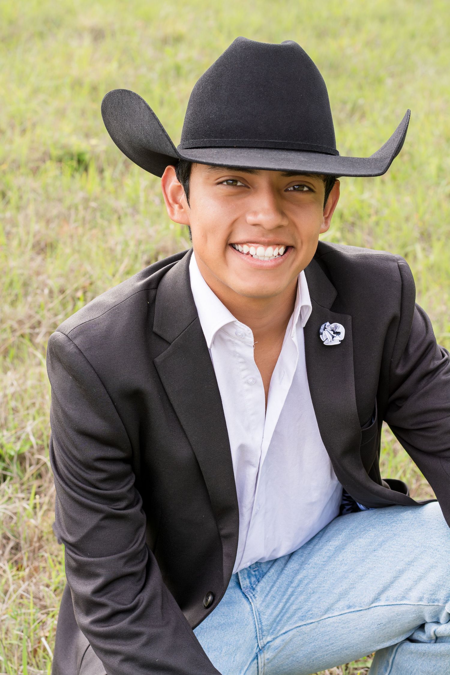 Western-style senior portrait series featuring a black cowboy hat and suit jacket.