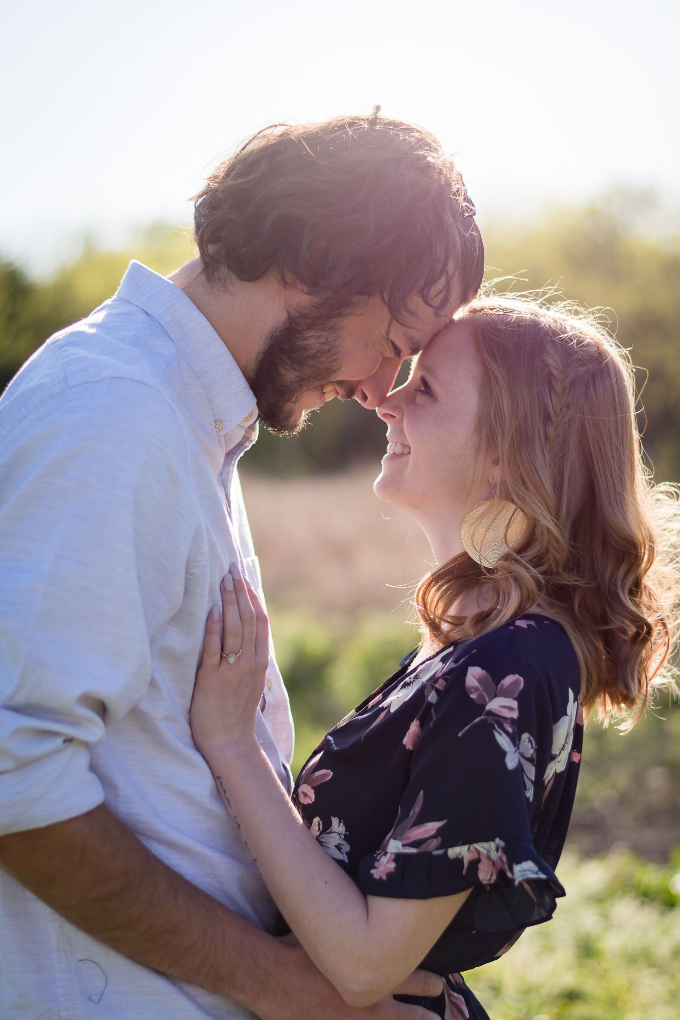 Romantic couple sharing an intimate moment in golden sunset lighting.