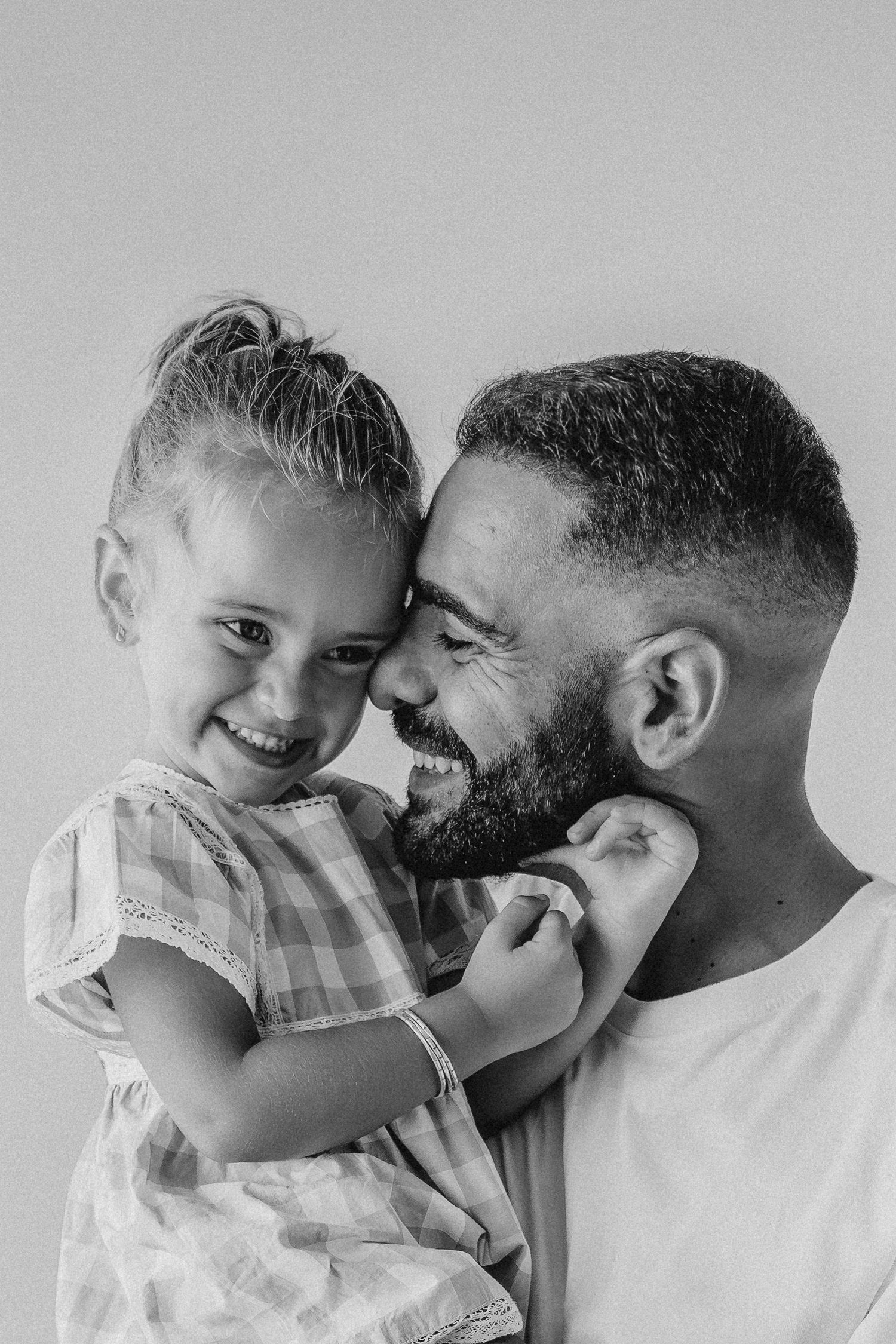 Padre abrazando a su hija pequeña en un retrato familiar en blanco y negro
