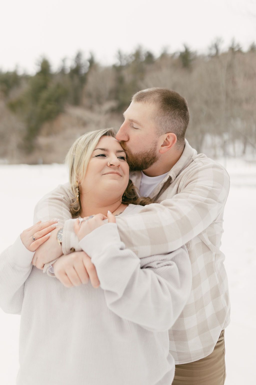 A tender embrace captured in a winter wonderland setting.