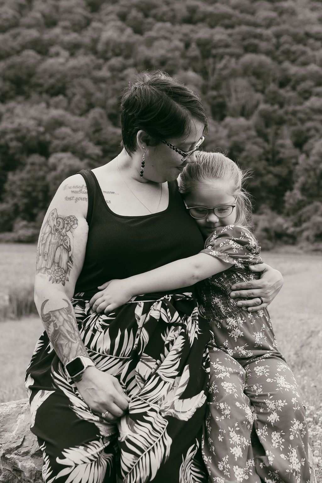 Black and white photo showing close affection between people wearing floral patterns.