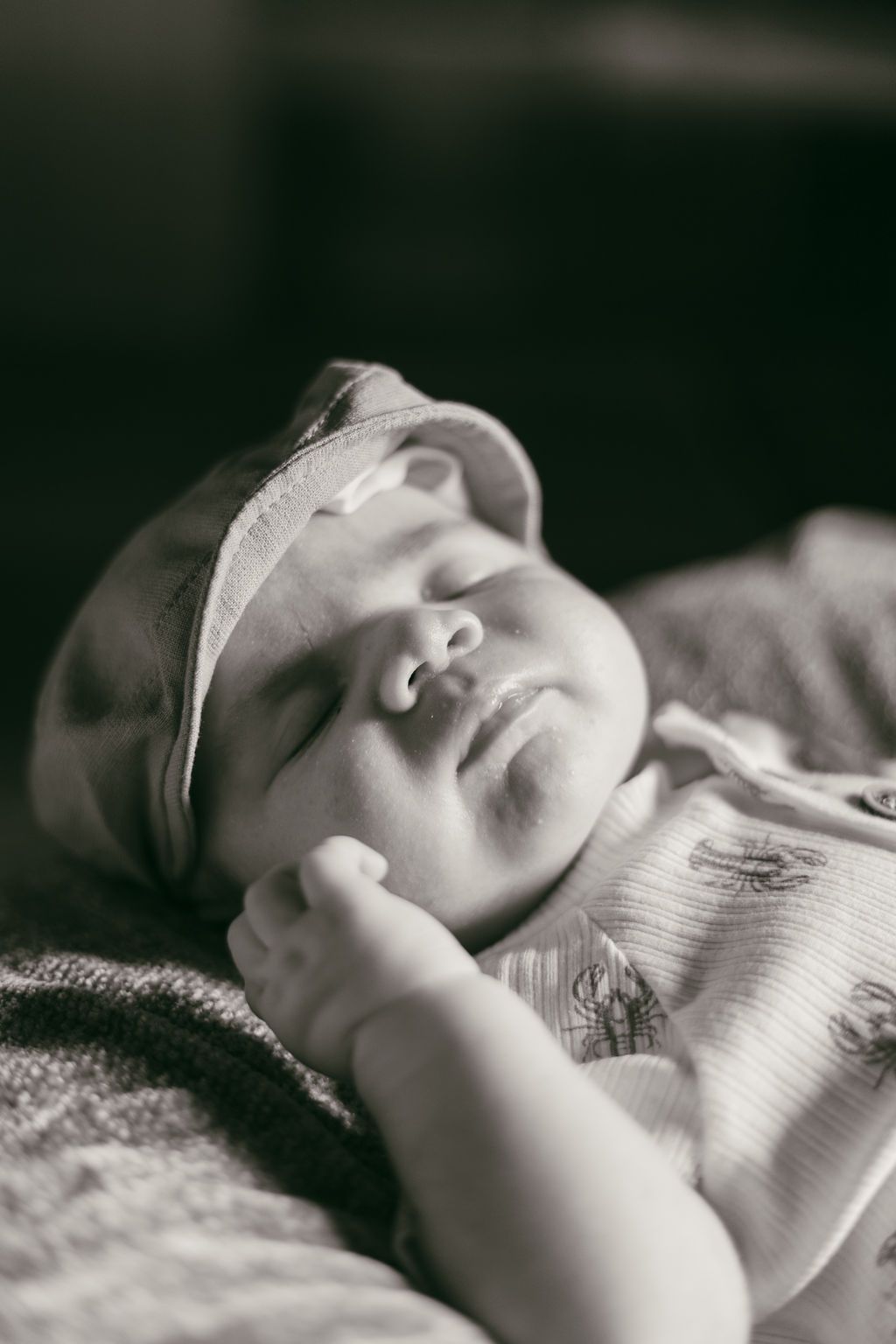 Black and white close-up portraits of sleeping newborn in soft lighting.