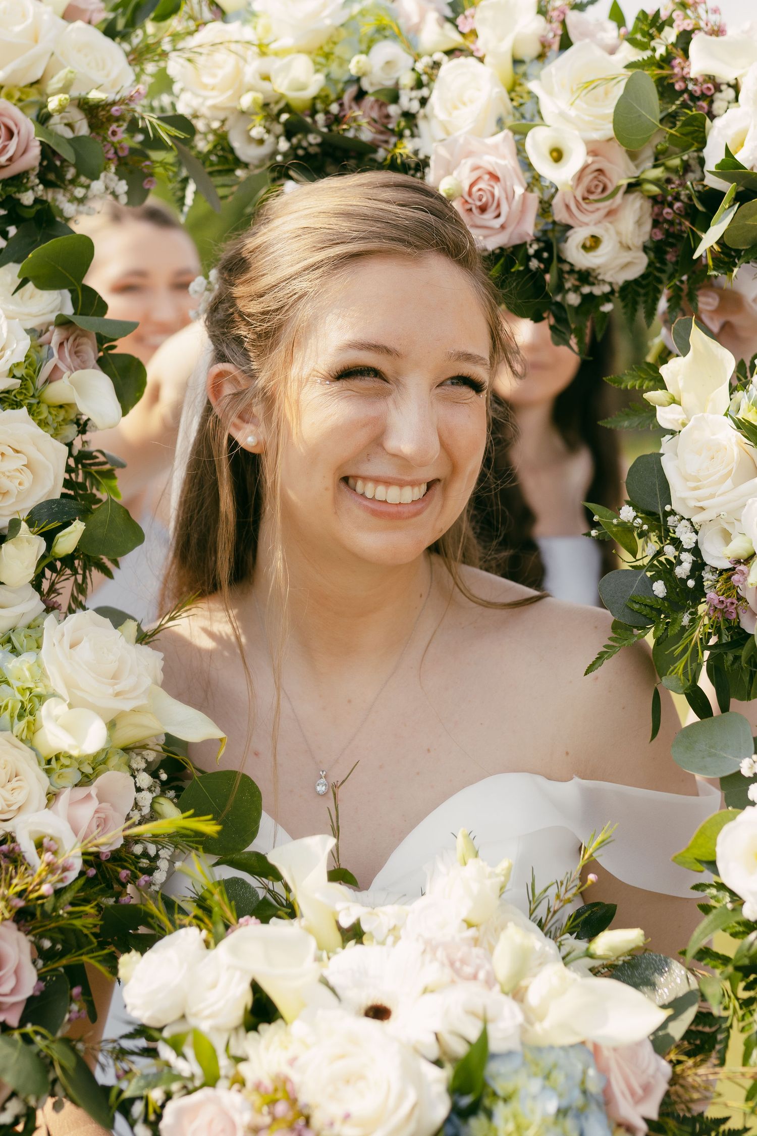 A bridal portrait surrounded by a beautiful arch of white and pink roses.