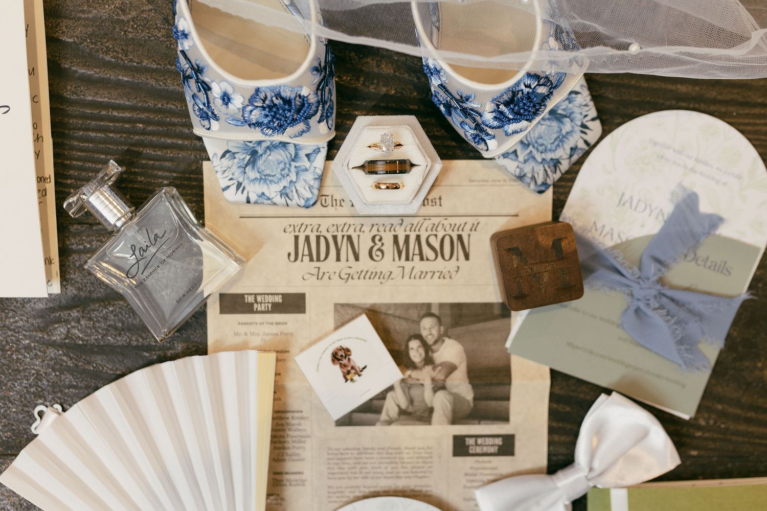 Wedding details flatlay with blue and white shoes, invitation, and decorative accessories.