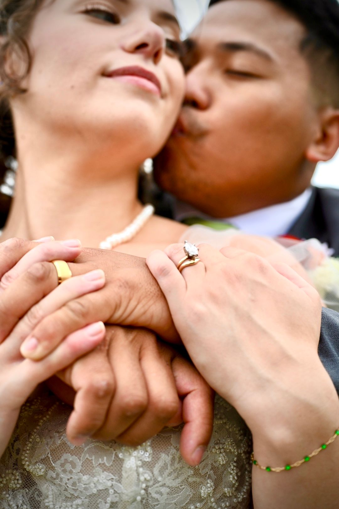 Artistic close-up photographs of wedding rings and clasped hands.