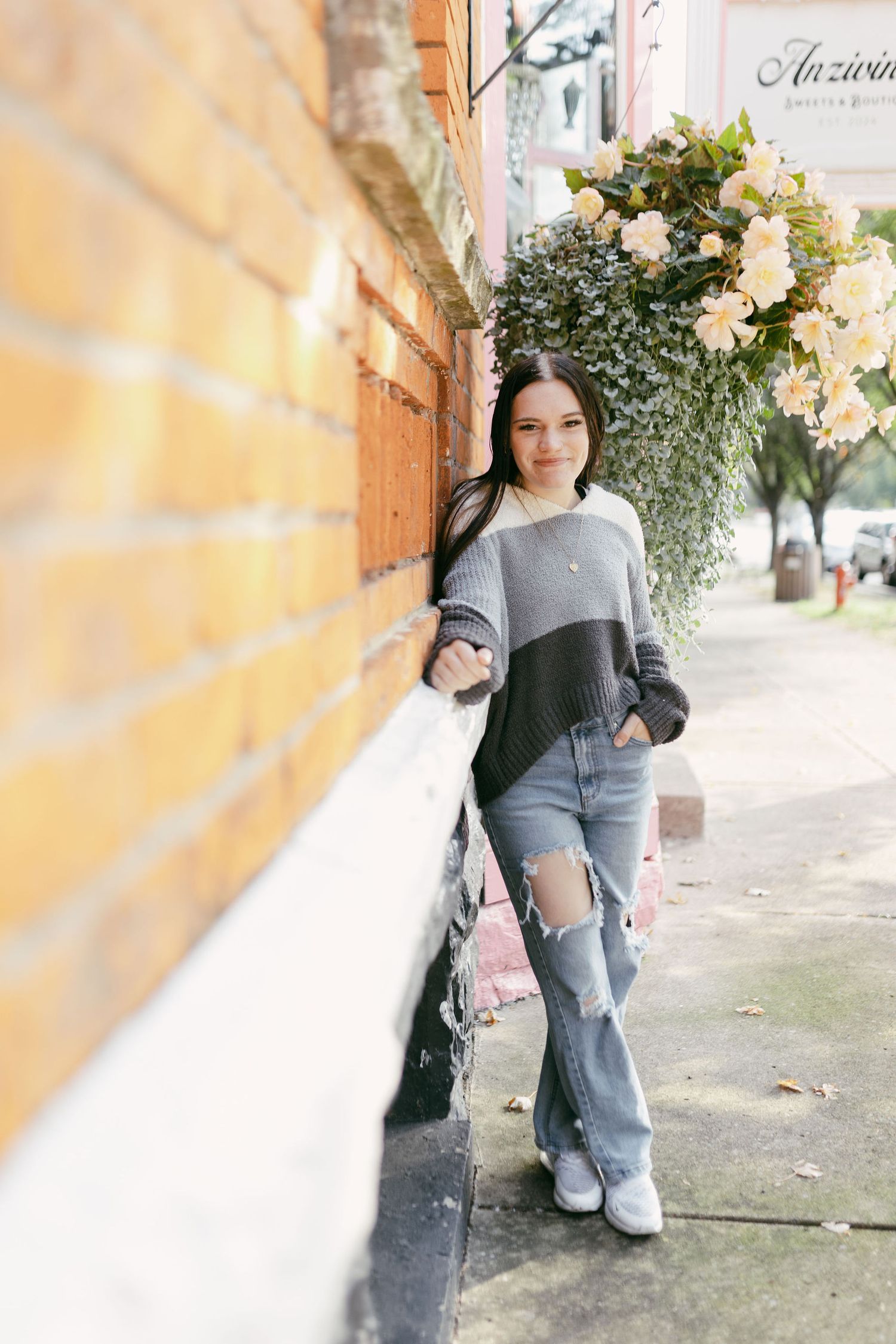 Casual street style photo against yellow wall with flowers.
