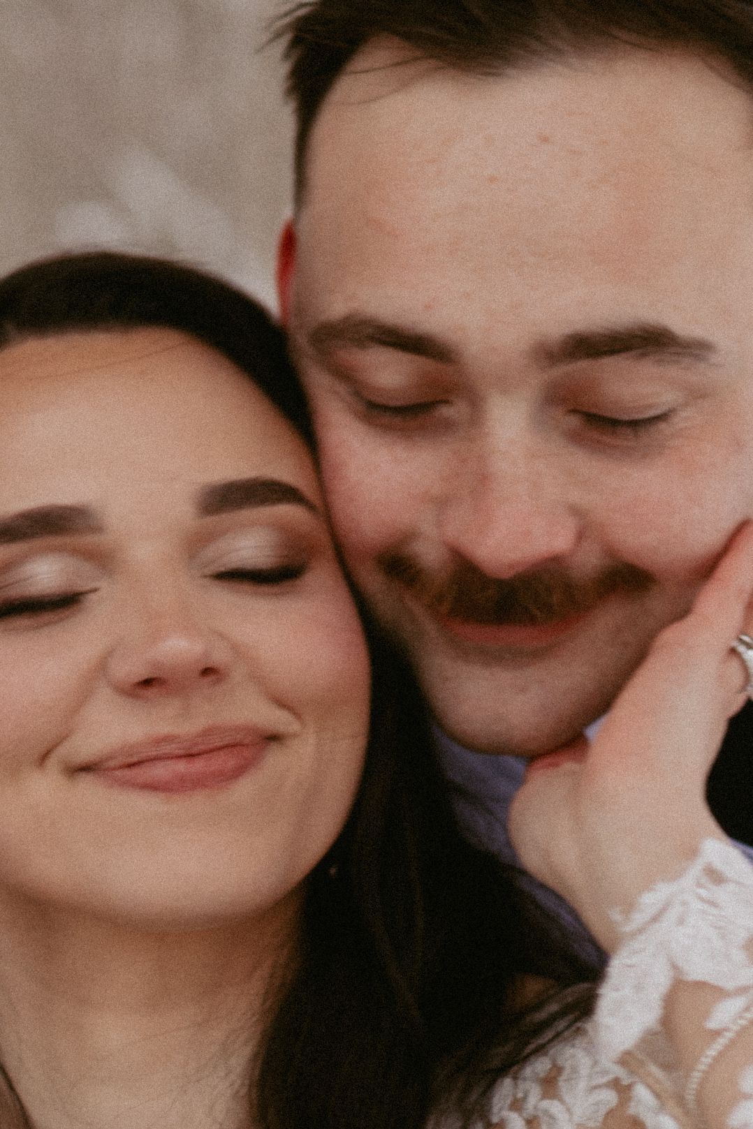 An intimate black and white wedding portrait showing a tender romantic moment.